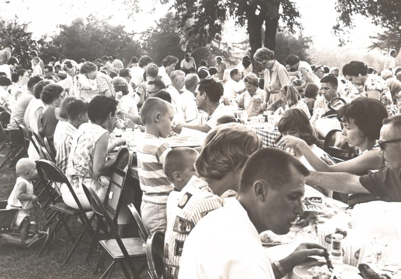 Click to expand image: group of community members eating food together