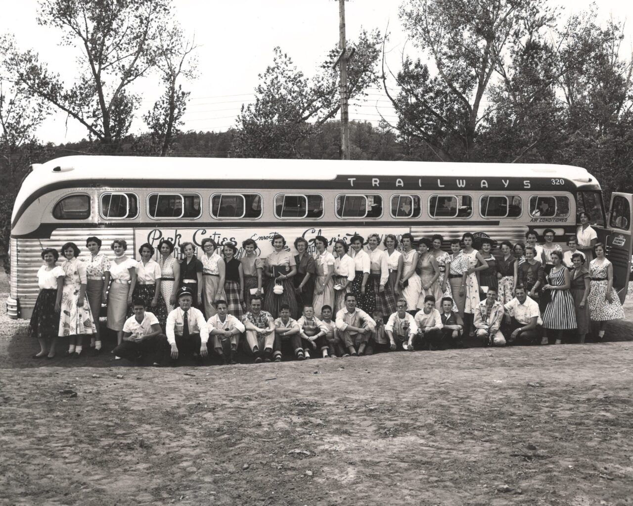 Click to expand image: community members in front of a bus